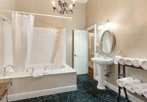 Bathroom with a Jacuzzi tub and elegant chandelier lighting