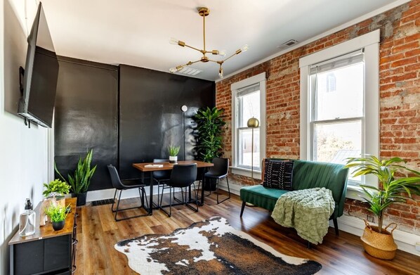 kick back in our cozy jungle-themed living room with smart tv & real plants 🌿 designed for connection & comfort, this living room is the heart of the home!