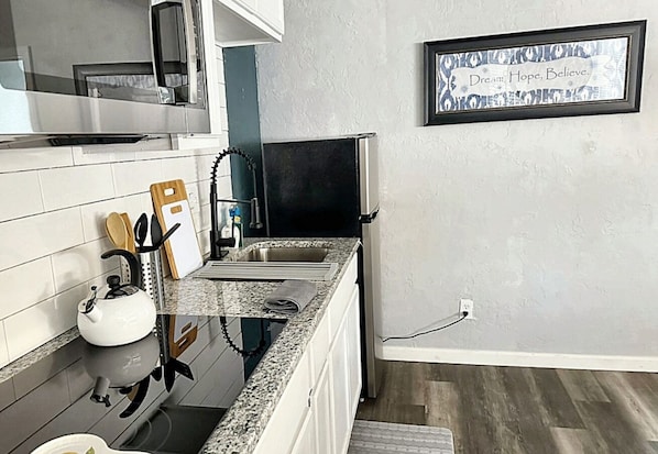 Whip up delicious meals in this compact yet functional kitchen, perfect for a cozy breakfast or a quick dinner.