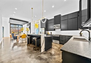 The open kitchen design balances function and style with modern appliances, sleek finishes, and plenty of room for cooking or entertaining.
