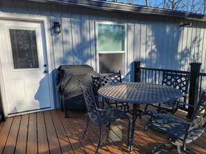Back deck, find a charcoal grill and outdoor dining table & chairs.