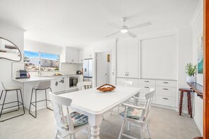 Open plan kitchen dining area with ceiling fan