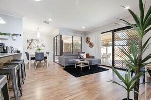 Open plan kitchen - dining and TV lounge leading to back pool area