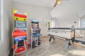 Loft game area ft. arcade games, foosball table, and plenty of board games.
