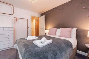 Soft ambient lighting, a luxurious king-sized bed adorned with high-thread-count linens, and bespoke furnishings create a sense of indulgence.