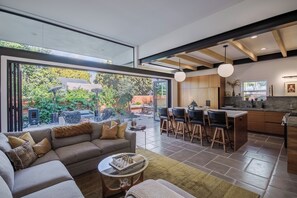 Kitchen and living room open up with California bifold doors to the outdoors