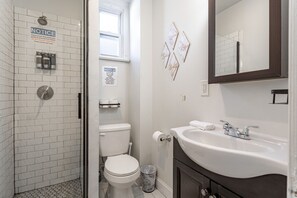 Private Bathroom Features a standing shower, vanity with mirror, toilet, hand towel ring, and essentials like soap and tissue—clean and convenient.