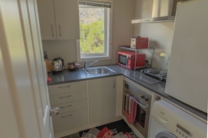 Kitchen with own washing machine. Dryer available in separate area.
