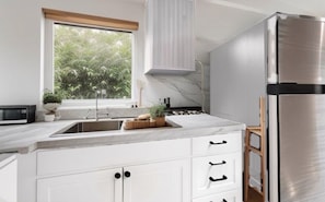 Large window over sink and stainless refrigerator