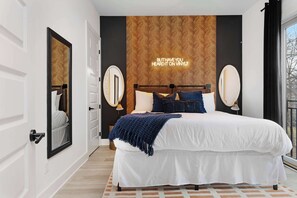 Comfortable bedroom with a king bed, walk-in closet, and an en-suite bathroom featuring a shower/tub combo with dual access from the bedroom and kitchen.