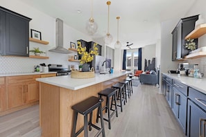 Modern kitchen featuring a spacious pantry and a large island with five barstools, perfect for casual dining or entertaining.