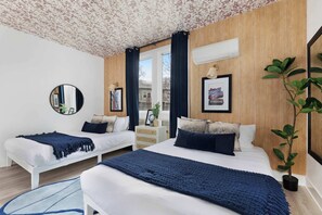 Spacious bedroom featuring two queen beds, a walk-in closet, and an en-suite bathroom with a sleek shower for ultimate comfort.