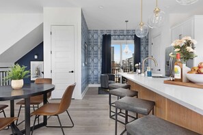 Modern kitchen featuring a spacious island with four barstools, perfect for dining, entertaining, and meal prep.