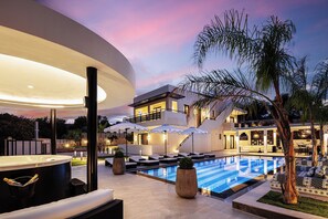Relax in the jacuzzi under the softly lit pergola.