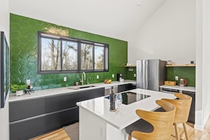 Experience a vibrant, refreshing kitchen where nature meets modern design. This stunning space features a bold green accent wall that brings a sense of calm and rejuvenation to the heart of your home.