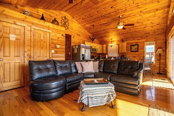 Cozy living area with vaulted wood ceilings, leather sectional, and scenic views.