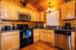 Modern kitchen with stainless appliances and rustic wood cabinets.