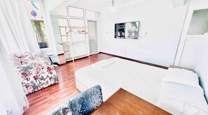 Room with bed, sofa, TV, desk, air conditioning and a balcony for a cozy stay.