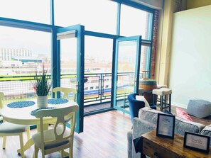 A cozy living area with modern furnishings and direct access to a balcony overlooking the water. Designed for comfort and scenic relaxation.