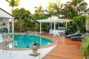 Lush greenery and thoughtfully landscaped plants surround the area, adding to the tranquility of the environment. The natural elements create a sense of privacy and seclusion, transforming the space into a peaceful retreat from the outside world.