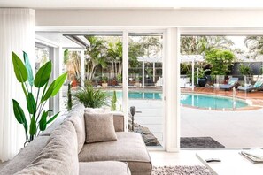 The living area offers an ideal view of the pool through its expansive glass doors. This setup creates the perfect vacation atmosphere, allowing you to relax in comfort while enjoying the scenic poolside vista.