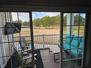Porch w/  seating, outdoor tv, ceiling fan and view of 4th hole 