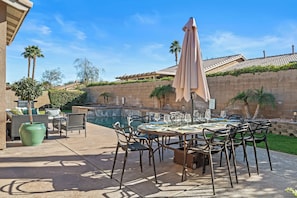 Private backyard with a pool, hot tub, and outdoor dining area.