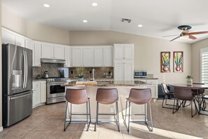 Fully equipped kitchen with barstool seating.