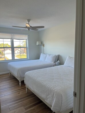 Southeast bedroom with two queen beds, spacious closet and slight view of lake.