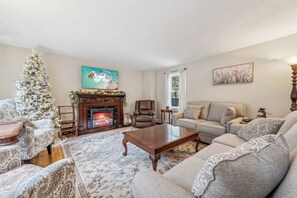 Upon entering the front door; Living room w/ large screen tv, elec. fireplace