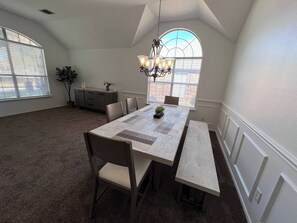 Enjoy meals and create lasting memories in this beautiful dining area, bathed in natural light from elegant arched windows. 