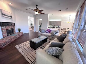 Step into the warmth and comfort of this modern yet cozy living space. The spacious sala invites you to relax on plush sofas, surrounded by natural light streaming through large windows.