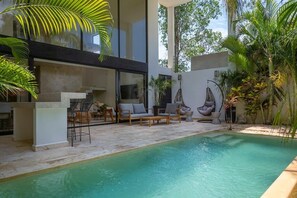 Impressive outdoor patio located next to the pool. It has comfortable and modern sofas and a bar for enjoyment.
