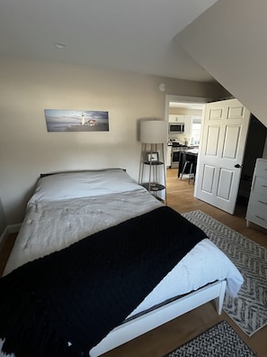 Cozy room with a queen bed, soft linens, and a charming bedside reading nook.