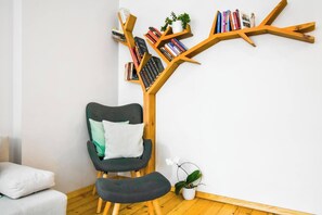 Unwind in the cozy reading nook, complete with a comfortable armchair and unique shelving design, ideal for a quiet moment with your favorite book.