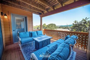 Covered balcony in Branson with blue outdoor seating and scenic wooded view