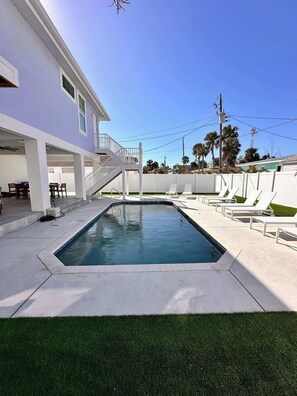 heated pool with 8 loungers, large fenced backyard
