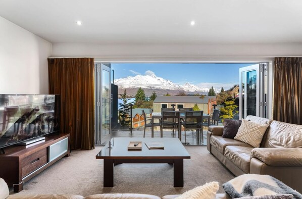 Living room with large floor to ceiling concertina doors which open out to the main level balcony.  