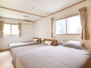・[Triple Room] A spacious bedroom with three semi-double beds.