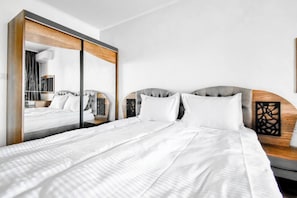 Sleep in comfort with a spacious bed, wardrobe, and modern decor.