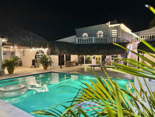 Relax by the sparkling pool surrounded by lush greenery and palm-thatched cabanas, or enjoy a quiet evening on the elevated balcony with stunning views.