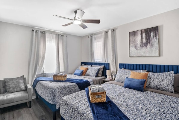 Cozy and functional with two queen beds, flat screen Roku TV, an extra seating area, ceiling fan, and ample storage.