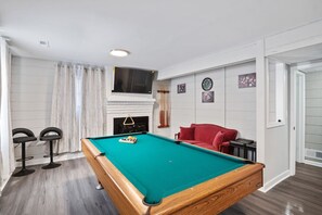Just three steps down, discover a fun and functional basement space with a pool table, flat-screen Roku TV, small sofa, and extra seating. A dining nook with ample seating makes this area perfect for gathering. Woodstove is decorative!