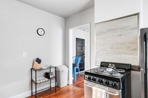 A fully equipped, well-lit space with an oven range, Keurig, dishwasher, and thoughtful touches like a paper towel dispenser. Perfect for whipping up meals or enjoying your morning coffee.
