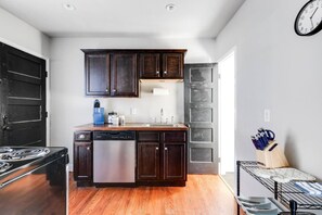 A fully equipped, well-lit space with an oven range, Keurig, dishwasher, and thoughtful touches like a paper towel dispenser. Perfect for whipping up meals or enjoying your morning coffee.