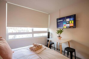 Unwind in this cozy studio apartment featuring a comfortable bed and stylish décor.