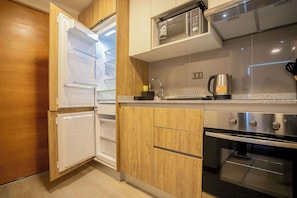 Modern kitchen with sleek appliances and warm wooden cabinetry, perfect for preparing meals during your stay.