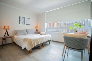 Relax in this modern bedroom with city views, stylish decor, and cozy ambiance—your perfect retreat awaits!