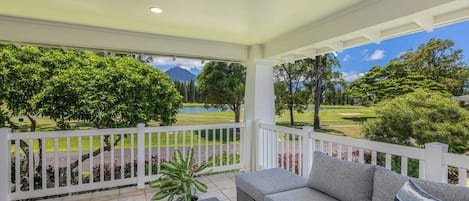 Unwind on the covered patio with plush seating and peaceful green views.