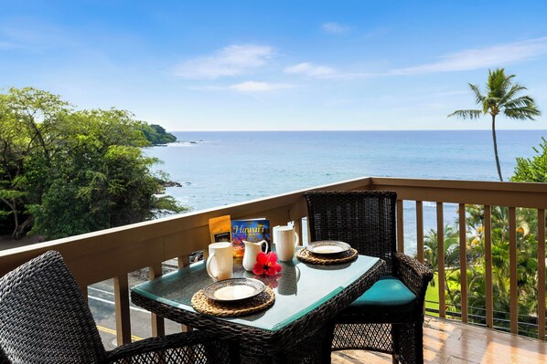 Oceanfront breakfast on a private balcony with seating for two, offering stunning water views.